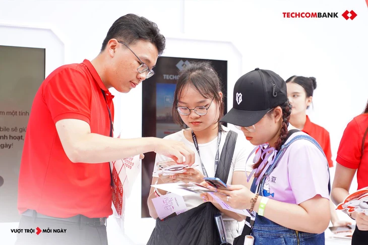Sinh lời tự động 2.0 ra mắt, Techcombank khẳng định vị thế tiên phong 1 Nhân viên Techcombank hướng dẫn khách hàng bật tính năng sinh lời tự động